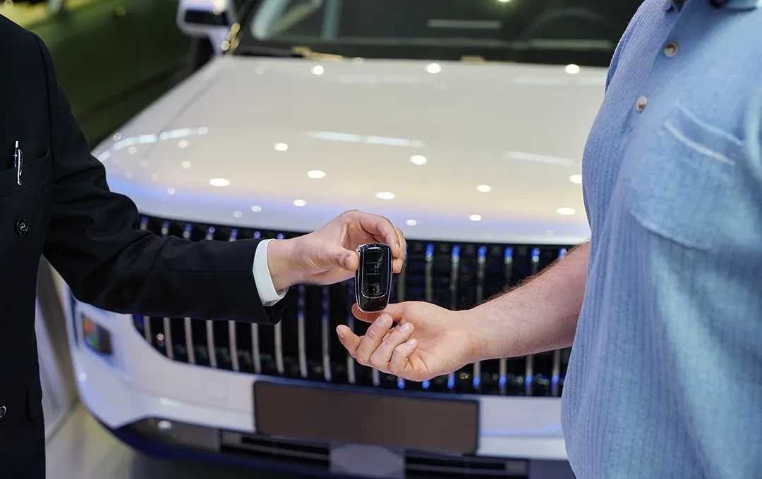 Persoană care primește cheile mașinii cumpărate prin credit auto, de la un reprezentant bancar sau dealer